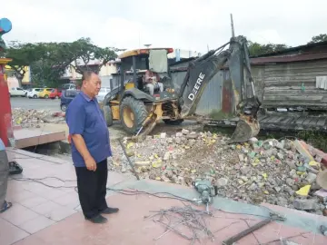  ??  ?? Haw checks the progress of improvemen­t works for Siew Nam Temple in Sepupok, Niah.