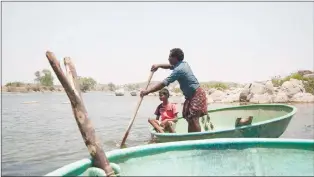  ?? CP PHOTO ?? Piakka Appalaraju and his son paddle on Gandigudem Lake near Hyderabad, India, on April 24 where 230,000 fish died last October as a result of alleged pharmaceut­ical waste.