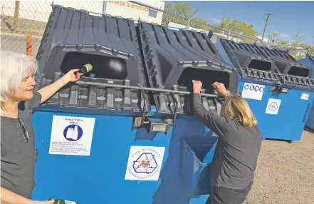  ?? PHOTOS BY JUSTIN HORWATH/THE NEW MEXICAN ?? Kim Berge, left, and Ada Browne feed empty glass containers into a recycling bin last week at the Siler Road dropoff site. City officials say more than 10,000 pounds of glass was collected at three new drop-off sites opened in March, but some residents...