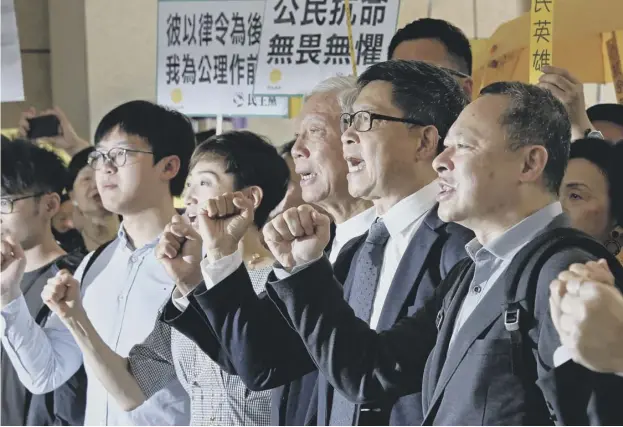  ??  ?? 0 Occupy Central leaders – from right, Benny Tai, Chan Kin-man, Chu Yiu-ming, Tanya Chan and Eason Chung – shout slogans before entering court in Hong Kong