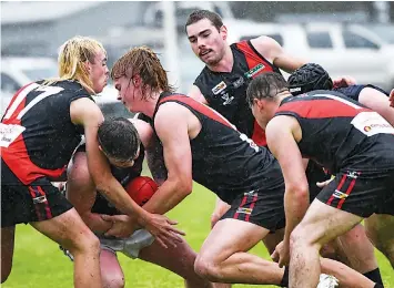  ?? ?? Catani’s Travis Broman is surrounded by Nilma Darnum players in the wet conditions.