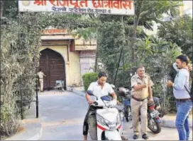  ?? HIMANSHU VYAS/HT ?? Police guard as a man carries garbage cans from Rajput Hostel in Jaipur on Sunday. The hostel has been quarantine­d in view of the spread of Zika cases.