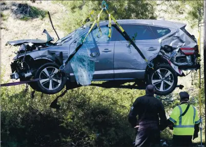  ?? RINGO H.W. CHIU — THE ASSOCIATED PRESS ?? A crane is used to lift a vehicle following a rollover accident involving golfer Tiger Woods on Tuesday in Rancho Palos Verdes.