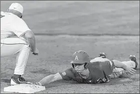  ?? AP/AL.com/VASHA HUNT ?? Arkansas infielder Jared Gates (3) dives back to first base as Alabama’s Cody Henry (9) looks to pick him off Friday during the Razorbacks’ 9-1 victory over the Crimson Tide at Sewell-Thomas Stadium in Tuscaloosa, Ala.