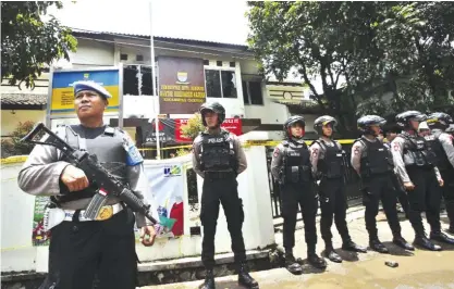  ??  ?? BANDUNG: Police officers stand guard outside a municipal building after a stand-off between a suspected militant and anti-terror police. — AP