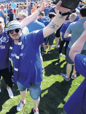  ??  ?? > Cardiff City fans celebrate after winning promotion to the Premier League