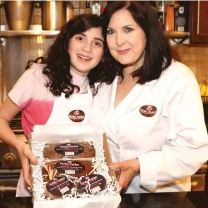  ?? THOMAS KIENZLE ?? The Hungry Monkey Baking Co. founder and owner Cindy Kienzle and her daughter Lily present their Social Distancing Treat Box, which was recently promoted by Howie Mandel on Talkshop Live.