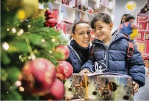  ?? FOTO: RALF MATZERATH ?? Vorfreude auf Weihnachte­n: Auch dieser Junge und seine Mutter holten sich gestern in der Galeria Kaufhof ein Geschenk ab.