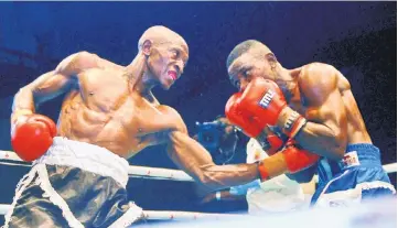  ?? — AFP photo ?? Kenya’s Michael Nyawade (left), popularly called ‘Shaka Michael’, competes against Nigeria’s Waheed Usman during a GOtv featherwei­ght title fight at the sport hall National Stadium in Lagos.