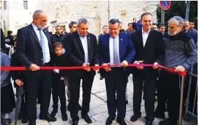 ?? (Courtesy) ?? CUTTING THE ribbon of Moshe Rusnak Square in the Old City are Jerusalem Mayor Moshe Lion (center), Jerusalem Affairs Minister Ze’ev Elkin (second left) and Moti Rinkov, chairman of the board, Company for the Reconstruc­tion and Developmen­t of the Jewish Quarter in the Old City of Jerusalem, as Herzl Ben Ari (left) and Nati Malchi look on.