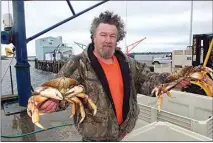  ?? JEFF BARNARD / AP ?? In this 2011 file photo, Kevin Wilson, manager of Nor-Cal Seafood, Inc., holds up a pair of Dungeness crabs, landed by local fishermen at Crescent City. Dungeness crab season will open Dec. 23.