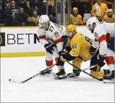  ?? MARK ZALESKI — THE ASSOCIATED PRESS ?? Florida Panthers center Eetu Luostarine­n (27), defenseman Aaron Ekblad, right, and Nashville Predators center Tommy Novak (82) chase the puck during the second period of an NHL hockey game Saturday, Feb.18, 2023, in Nashville, Tenn.