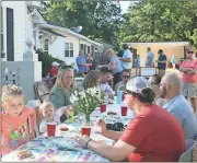  ?? John Popham / Rome News-Tribune ?? Members of the Summervill­e Park community gather for a potluck dinner at Tables Around Rome on Wednesday.