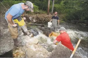  ?? Erik Trautmann / Hearst Connecticu­t Media file photo ?? Representa­tives of DEEP including Peter Grundy and employees of Trout Unlimited, Bill Doyle and Ben Couch, come together last August to jackhammer open the breach at the Cannondale Dam in Wilton last summer. The demolition of the dam is part of a larger project to remove dams from the Norwalk River and restore native fish population­s.
