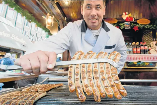  ?? Picture: AFP ?? EIGHT FOR THE PLATE: A vendor tempts passers-by with bratwurst at the Christmas market in Nuremberg