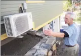  ?? Tyler Sizemore / Hearst Connecticu­t Media ?? Local builder and home owner Mike Troelle shows his electric heat pump outside of his energy-efficient home near Waubeeka Lake in Danbury.