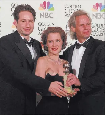  ?? Mark J. Terrill The Associated Press ?? “X-Files” co-stars David Duchovny, left, and Gillian Anderson, with series creator Chris Carter at the 1998 Golden Globe Awards.