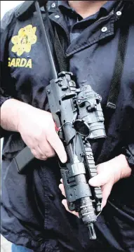  ??  ?? A garda carries a Heckler &amp; Koch MP7 submachine gun like the one found on a street in Dublin city centre yesterday