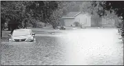  ?? AP/The Galveston County Daily News/KELSEY WALLING ?? A car is submerged in floodwater Tuesday in La Marque, Texas. The National Weather Service issued a flash flood watch for the Houston area and parts of Southeast Texas until Tuesday night amid rain and scattered street flooding.