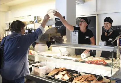  ??  ?? Systrarna Holmberg betjänar en kund vid fiskdisken på Holmbergs Fisk & Café Four C. Clara Holmberg-Nordell (t.v.) och Carina Holmberg (t.h.) öppnade samma år som konkursen och kaféet har blivit Dalsbruksb­ornas andra vardagsrum.