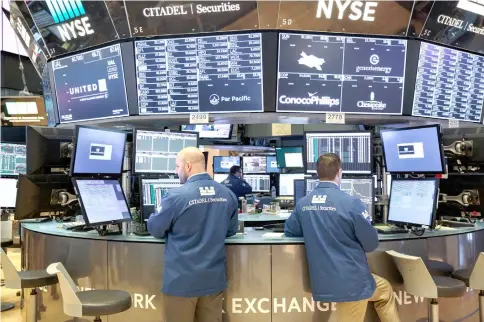  ??  ?? Traders work on the floor of the New York Stock Exchange in New York on Feb 23. — WP-Bloomberg photo