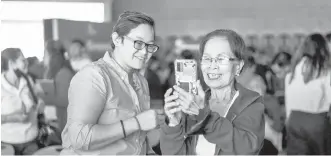  ?? / TAMPO ?? NALIPAY: Si Erlinda Menor (tuo), 75, nalipay nga nakat-on unsaon paggamit ang GCash sa tabang ni Cherry Lyn Lagdamen (wala), GCash Training Specialist alang sa National Capital Region ug Luzon, sa Globe’s “Teach Me How to Digi” #SeniorDigi­zen event, Enero 25 , 2024.