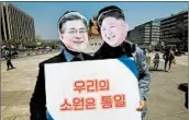  ?? JUNG YEON-JE/GETTY-AFP ?? South Korean activists push for unificatio­n as they wear masks of South Korea’s, left, and North Korea’s leaders.