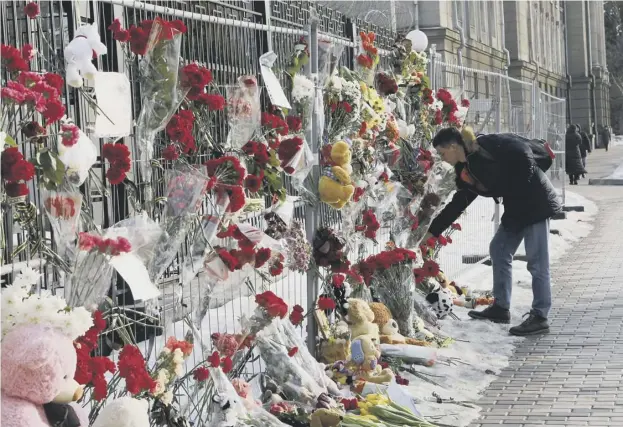  ??  ?? 0 A man lays flowers at the Russian embassy in Kiev, Ukraine, to pay tribute to victims of Sunday’s fire in a multi-storey shopping centre in Kemerovo