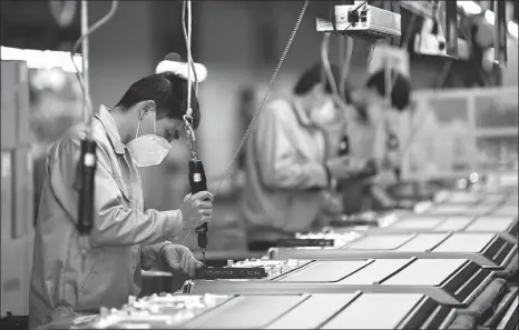  ?? DENG HUA / XINIHUA ?? Workers on the TV assembly line at a factory of Skyworth Group in Guangzhou, Guangdong province, on Feb 10.