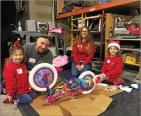  ?? SUBMITTED PHOTO ?? Pine Street Carpenter Jim Osborne and his family building a bike at the remodeling firm’s “100 Wheels Project” bike-build.