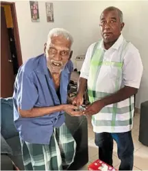  ?? ?? Hamidi (right) giving aid to an elderly man under the charity’s monthly donations to needy families.