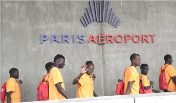  ??  ?? A migrant waves as he and others leave the immigratio­n hall at Roissy-Charles de Gaulle airport.