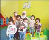  ??  ?? Dania Abdulbaqi (center), creche owner poses with children during an interview with AFP in Gaziantep inthe south-west province of Turkey on May 2. (AFP)