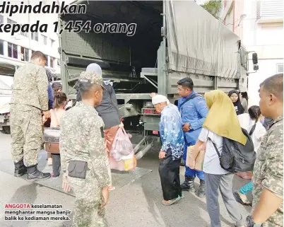  ??  ?? ANGGOTA keselamata­n menghantar mangsa banjir balik ke kediaman mereka.