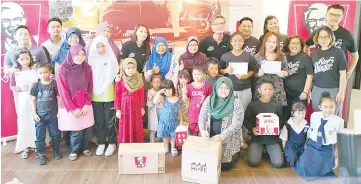  ??  ?? Scha (back, fifth left) and Lo (back, fourth right) with KFC Malaysia staff and recipients.