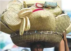  ??  ?? COLOMBO: A Sri Lankan vendor carries woven reed bags and baskets for sale on a street in Colombo yesterday. Sri Lanka’s unity government faced opposition from business leaders and the opposition to proposals to increase VAT by four per cent, from 11...