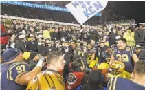  ?? PAUL W. GILLESPIE/CAPITAL GAZETTE ?? Navy football players celebrate with midshipmen after defeating Army, 31-7, in 2019 at Lincoln Financial Field in Philadelph­ia.