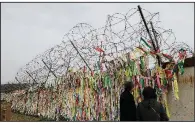  ?? AP/LEE JIN-MAN ?? Visitors at the Imjingak pavilion in Paju, South Korea, look Saturday at ribbons that carry messages wishing for reunificat­ion and peace between North and South Korea.