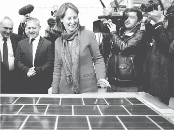  ??  ?? French minister for Ecology, Sustainabl­e Developmen­t and Energy Segolene Royal (centre) visits the factory plant during the launch of the work for the constructi­on of the first solar road in Tourouvre, northweste­rn France, on Oct 24. Solar roads aim at...