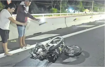  ?? ?? Vecinos del lugar observan cómo quedó la motociclet­a luego de la violentísi­ma colisión.