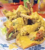  ??  ?? Crabs in rich and creamy salted egg sauce with curry leaves and chili from Keng Eng Kee