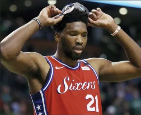  ?? ELISE AMENDOLA — THE ASSOCIATED PRESS ?? 76ers center Joel Embiid (21) lifts his face mask during a break in the fourth quarter against the Celtics in Game 1.