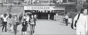  ??  ?? People walk under a sign in Almaty, Kazakhstan. The Russian language is more widespread across the country than Kazakh. (Photo: Getty Images)