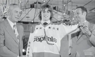  ?? CANADIAN PRESS FILE PHOTO ?? No. 1 draft pick Greg Joly tries on a jersey after he signed a deal with the Washington Capitals in Landover, Md., on May 28, 1974. The expansion ’74-75 Capitals remain statistica­lly the worst team in NHL history.