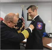  ?? ?? Perry Joint Fire District Chief James McDonald, left, pins a chief’s badge on his successor, fire District Lt. Dominic Chiappone, during a ceremony held May 6.