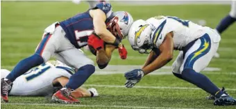  ?? AP PHOTO/CHARLES KRUPA ?? New England Patriots wide receiver Julian Edelman, left, collides with Los Angeles Chargers linebacker Uchenna Nwosu during the second half of their AFC divisional playoff game this past Sunday in Foxborough, Mass.