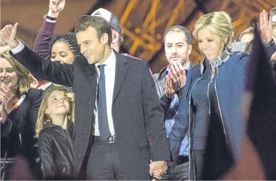  ?? Picture: Getty Images. ?? Emmanuel Macron and his wife Brigitte Trogneux hold hands as they celebrate his victory outside the Louvre.