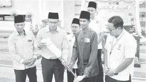  ?? ?? SANTUNI: Rahim (tiga kanan) menerima sumbangan berupa kaki palsu daripada Razi (dua kiri) pada Program Sejambak Kasih Aidilfitri di Masjid Al-Muttaqin, Samarahan semalam.