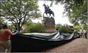  ?? AP ?? City workers prepare to drape a tarp over the statue of Confederat­e Gen. Thomas “Stonewall” Jackson in Justice Park in Charlottes­ville, Va., on Wednesday. A statue of Gen. Robert E. Lee was covered in Emancipati­on Park.