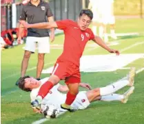  ?? STAFF PHOTO BY MATT HAMILTON ?? Dalton’s Filemon Quintero (9)tries to keep the ball in bounds as Baylor’s Jake Kellerhals looks on as he hits the turf at Harmon Field in Dalton, Ga. on Tuesday.